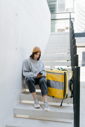 Delivery woman seating on stairs